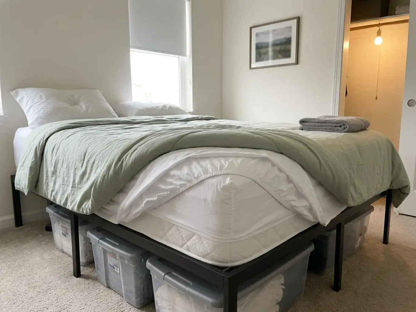 Guest bed with sheet, protector and comforter peeled back in a stair-step at one corner to show four bedding layers