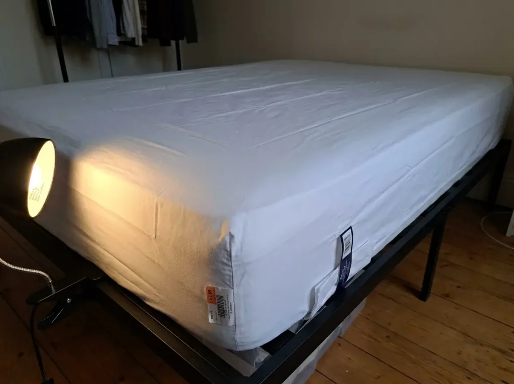 Cotton percale sheet raked by a low lamp so the plain one-over-one weave reads as tiny shadows