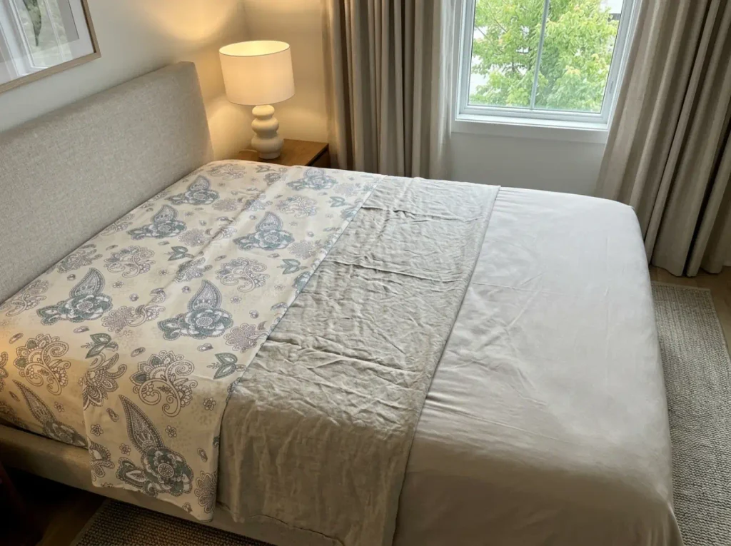 Percale, linen and a performance knit laid overlapping on a bed so the three weaves can be compared