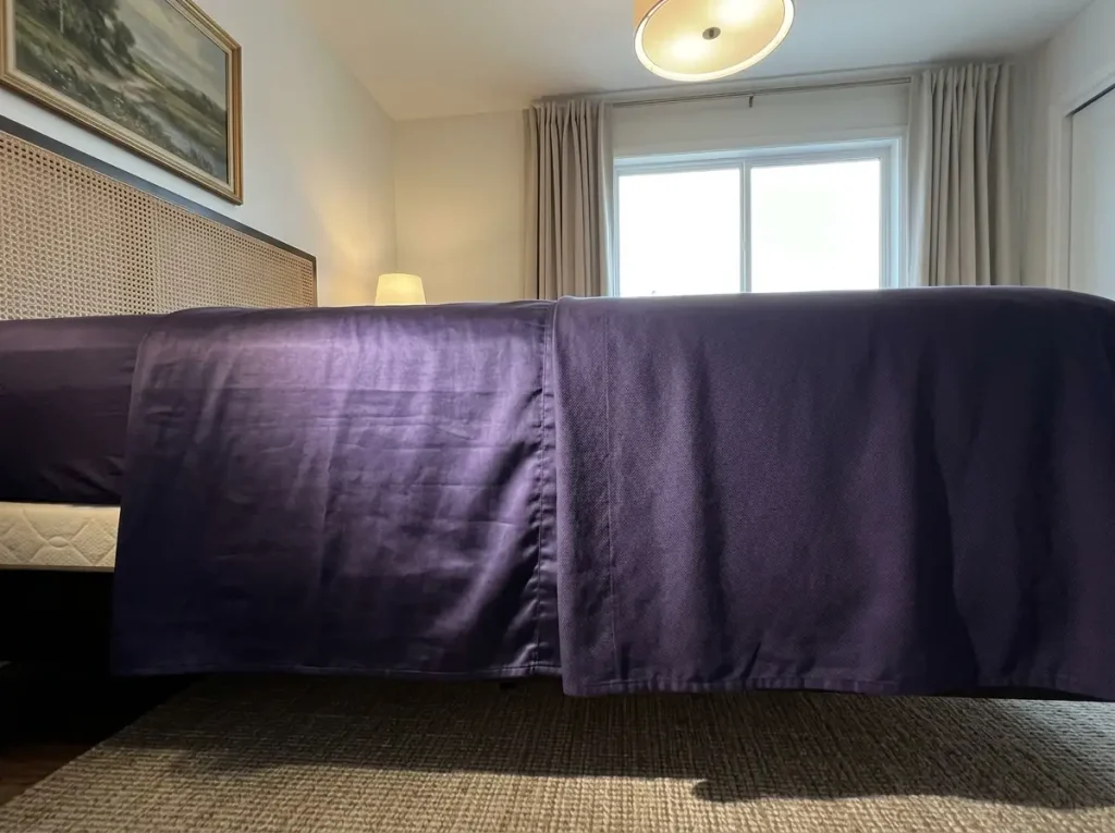 Two bamboo fabrics side by side under a raking lamp, one sateen with a sheen and one lyocell matte