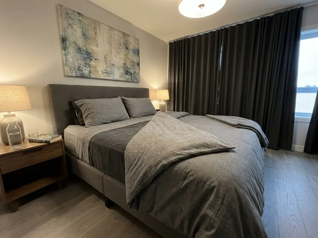 Flannel sheets turned back at one corner of a made bed in a cold new-build bedroom