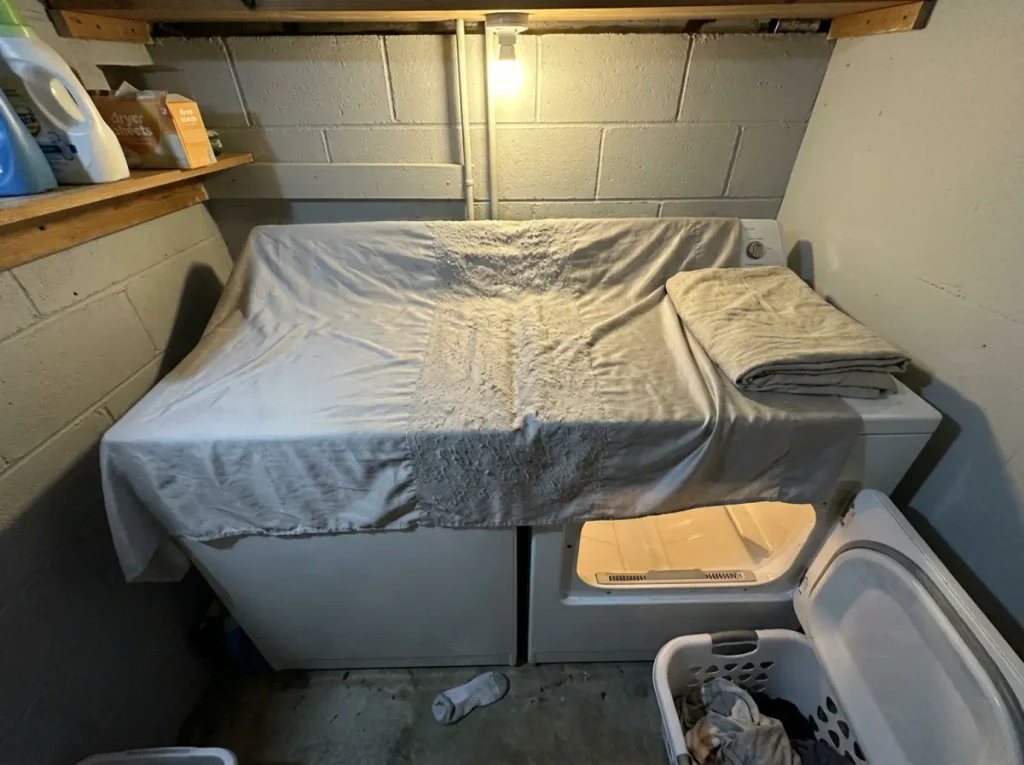 A much-washed bamboo sheet spread flat on a dryer lid with a pilled band across its middle