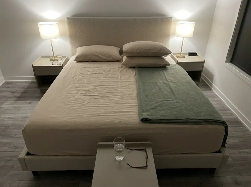One bed made two ways, a bare percale flat sheet on one side and a folded blanket on the other
