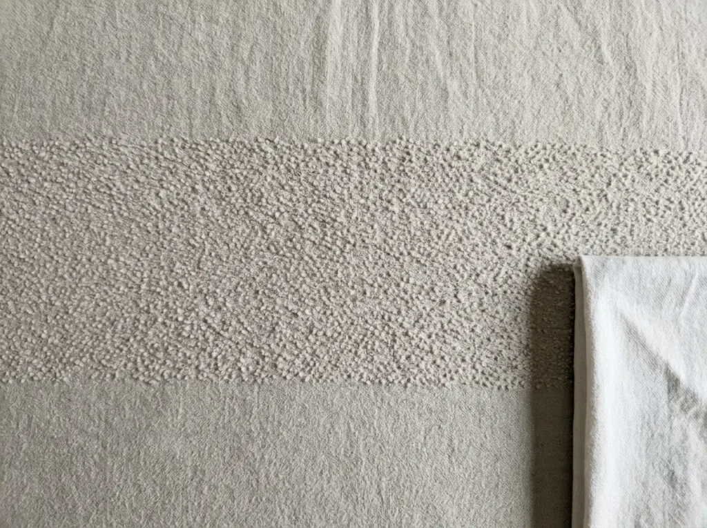 Close view of pilling across a band of a washed flannel sheet after a season of use